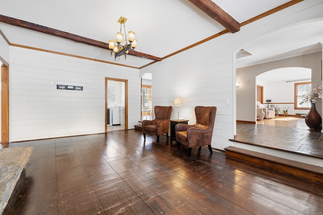 sitting room with beamed ceiling, dark hardwood / wood-style floors, and a chandelier