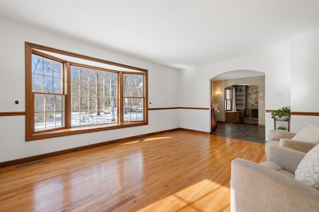 living room with a stone fireplace and light hardwood / wood-style floors