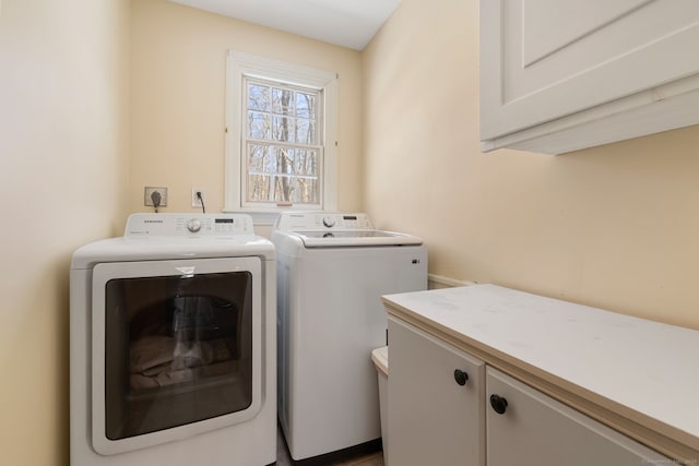 laundry room featuring washer and clothes dryer and cabinets