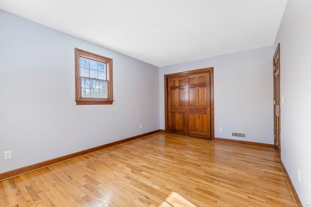 unfurnished bedroom with light wood-type flooring and a closet