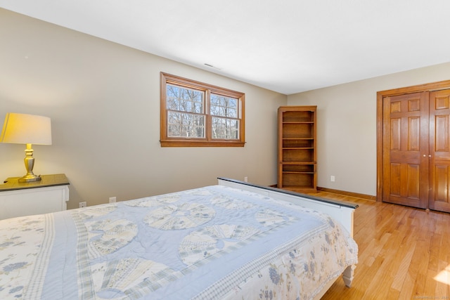 bedroom with a closet and light hardwood / wood-style flooring