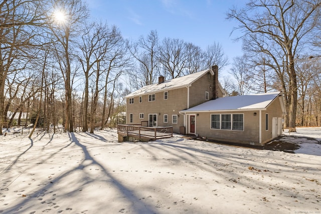 snow covered rear of property featuring a wooden deck