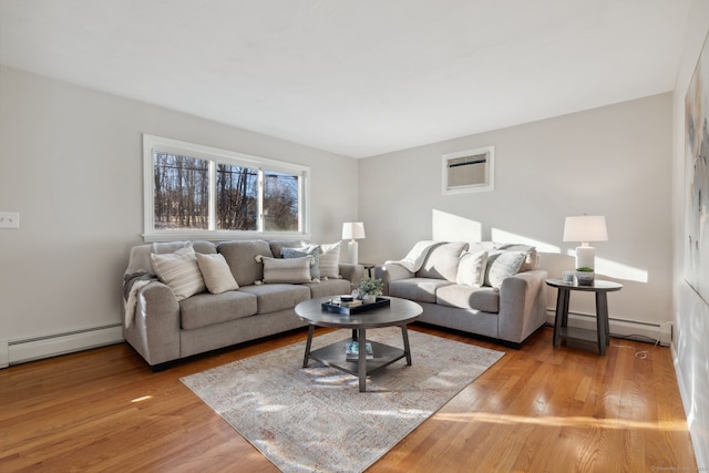 living area featuring a wall mounted AC, light wood-type flooring, and a baseboard radiator