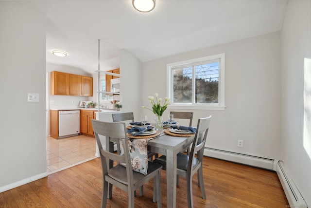 dining room featuring light wood-style floors, baseboards, and a baseboard radiator