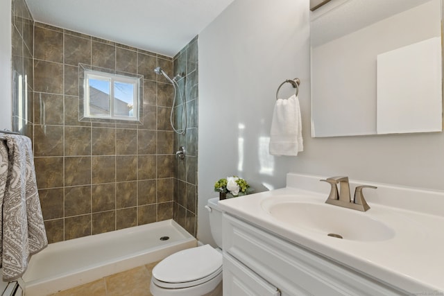 bathroom featuring toilet, a baseboard heating unit, tiled shower, and vanity