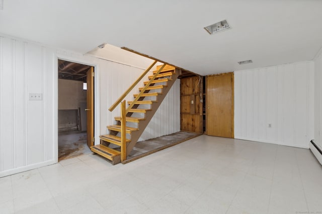 finished basement with tile patterned floors and stairway