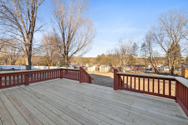 wooden deck featuring a storage unit, an outbuilding, and a fenced backyard