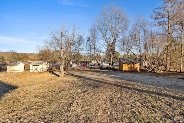 view of yard with an outdoor structure, fence, and a shed