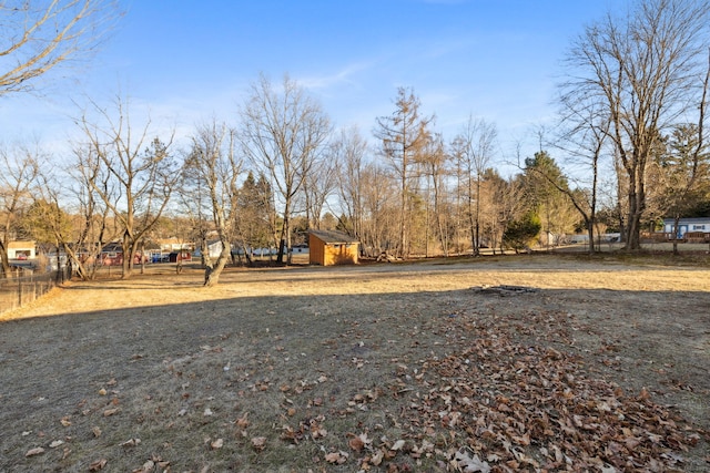 view of yard with an outbuilding, a shed, and fence