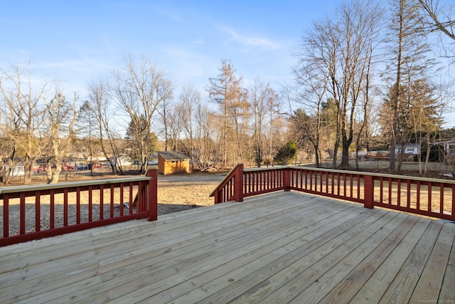 wooden deck with a storage unit and an outbuilding