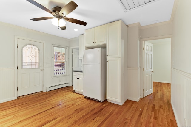 kitchen with a baseboard heating unit, ceiling fan, light hardwood / wood-style floors, ornamental molding, and white fridge