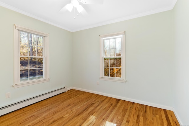 empty room featuring light wood-type flooring, crown molding, a wealth of natural light, and a baseboard radiator