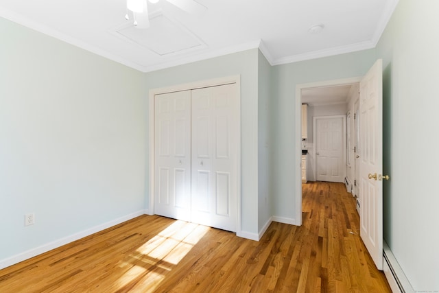 unfurnished bedroom featuring ceiling fan, a baseboard heating unit, light hardwood / wood-style floors, a closet, and ornamental molding