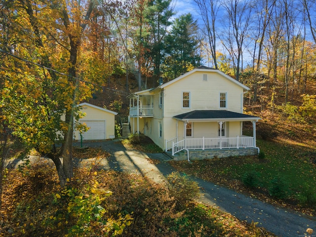 view of front facade with covered porch, an outdoor structure, and a garage