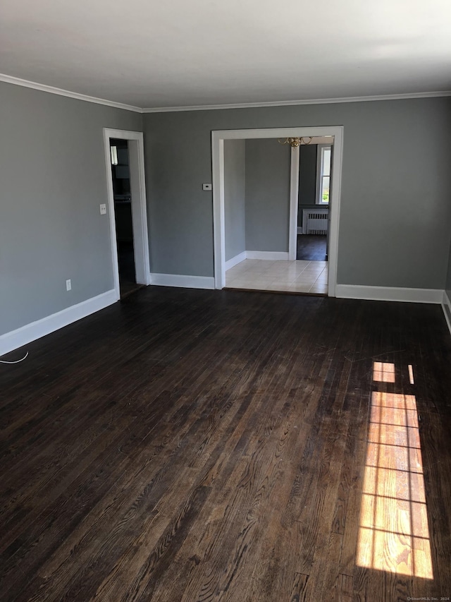 empty room with radiator, dark hardwood / wood-style flooring, and ornamental molding