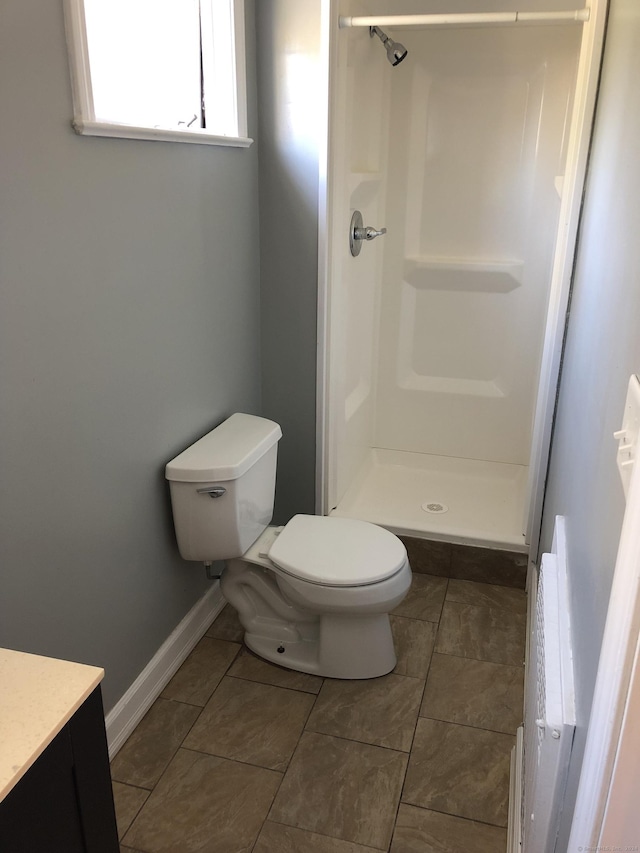 bathroom featuring radiator, tile patterned flooring, a shower, toilet, and vanity