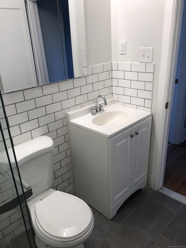 bathroom featuring tile patterned floors, vanity, tile walls, and toilet