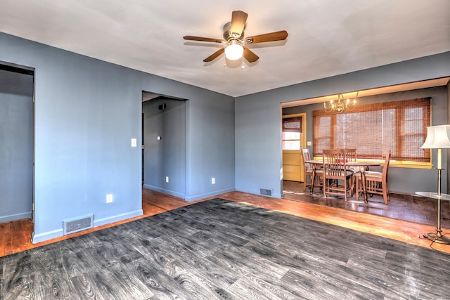 interior space featuring ceiling fan with notable chandelier and dark hardwood / wood-style flooring