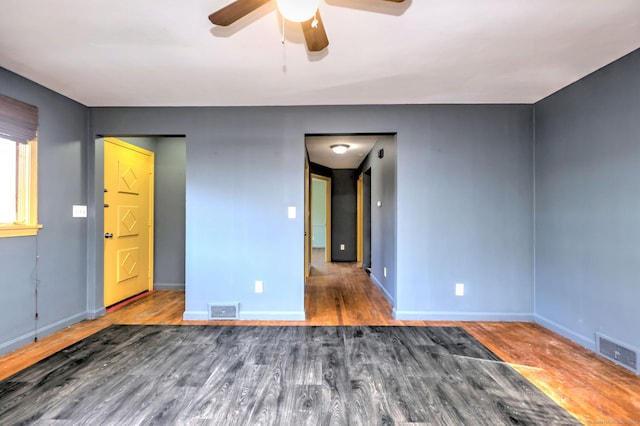 empty room featuring dark hardwood / wood-style flooring and ceiling fan