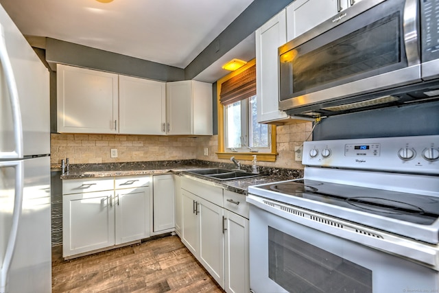 kitchen with tasteful backsplash, white appliances, sink, dark hardwood / wood-style floors, and white cabinetry