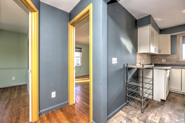 kitchen with decorative backsplash, white cabinets, a healthy amount of sunlight, and dark hardwood / wood-style floors