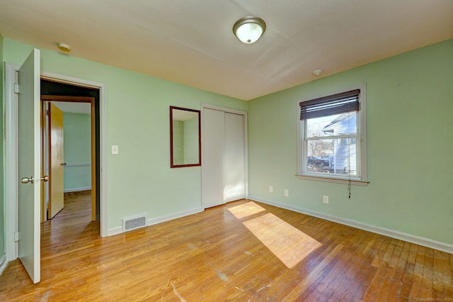 unfurnished bedroom with light hardwood / wood-style flooring and a closet