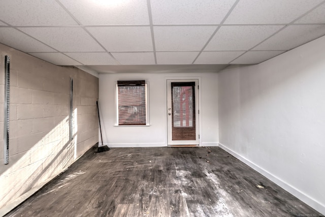 spare room featuring a paneled ceiling and dark hardwood / wood-style floors