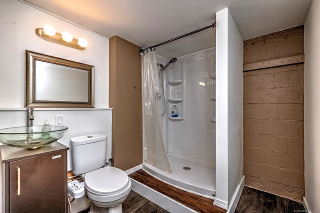 bathroom featuring hardwood / wood-style flooring, vanity, toilet, and walk in shower