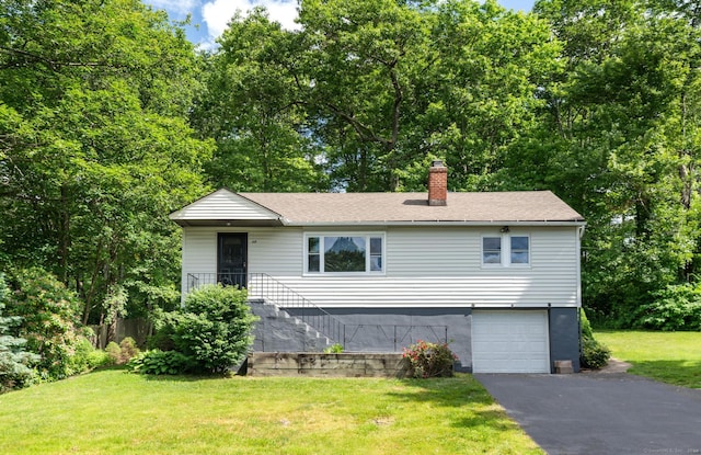 view of front of property with a garage and a front lawn