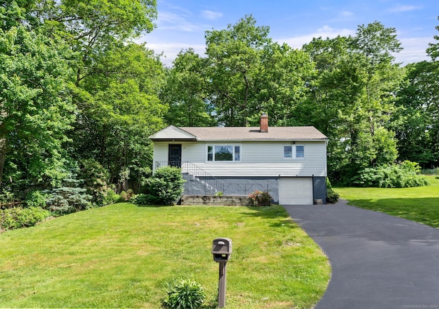 view of front of home featuring a front yard and a garage