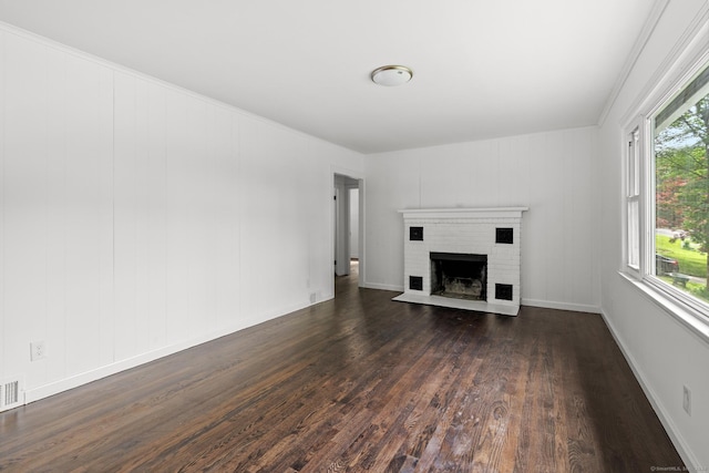 unfurnished living room with dark hardwood / wood-style floors, ornamental molding, and a fireplace