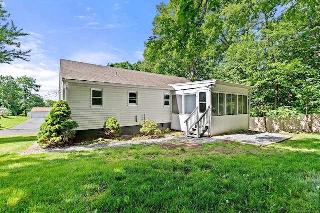 rear view of house with a sunroom and a yard