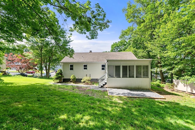 back of house with a yard and a sunroom