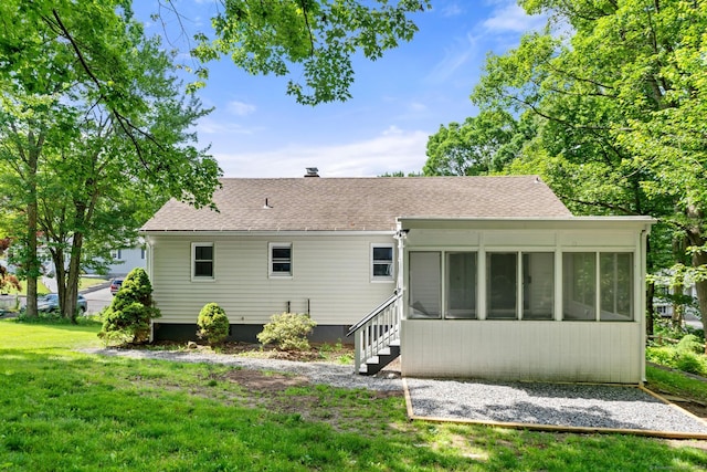 rear view of property with a sunroom and a lawn