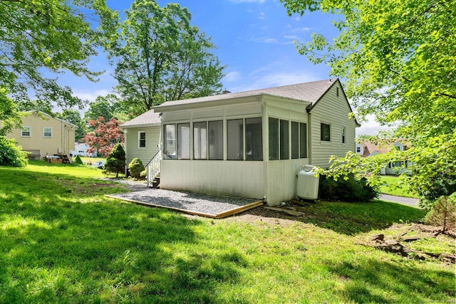 back of house featuring a sunroom and a yard