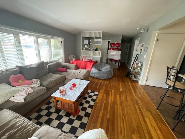 living room featuring dark hardwood / wood-style floors and vaulted ceiling