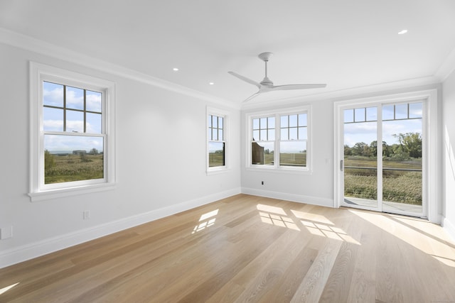 unfurnished room featuring ceiling fan, light wood-type flooring, and ornamental molding