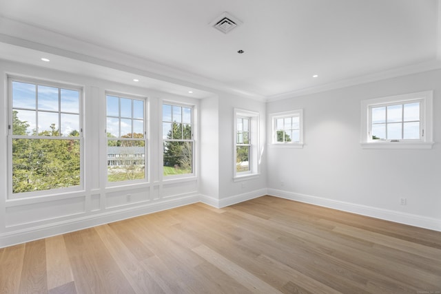 unfurnished room with light wood-type flooring and crown molding