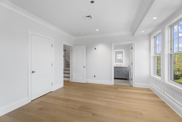 unfurnished bedroom with ensuite bathroom, crown molding, and light hardwood / wood-style floors