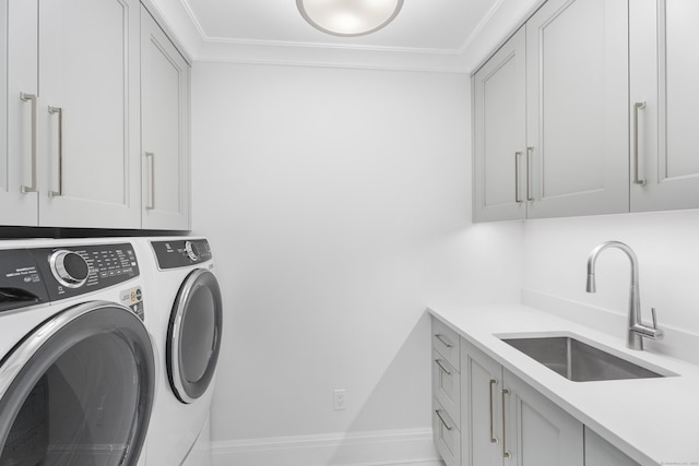 clothes washing area featuring cabinets, separate washer and dryer, sink, and ornamental molding