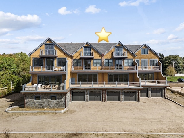 rear view of property with a balcony and a garage