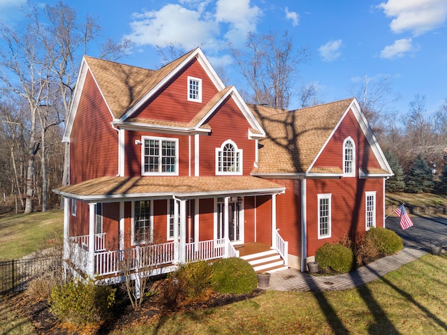 view of front of property featuring covered porch and a front lawn