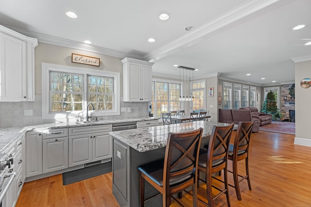 kitchen with a kitchen breakfast bar, a center island, light hardwood / wood-style floors, and white cabinetry