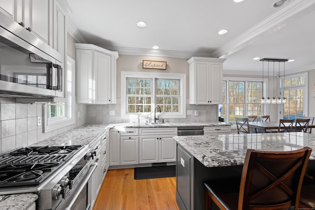 kitchen with decorative backsplash, white cabinetry, stainless steel appliances, and a wealth of natural light