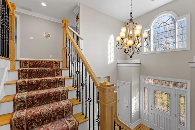 foyer featuring an inviting chandelier and ornamental molding