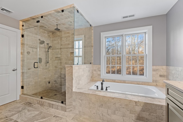 bathroom featuring vanity and independent shower and bath