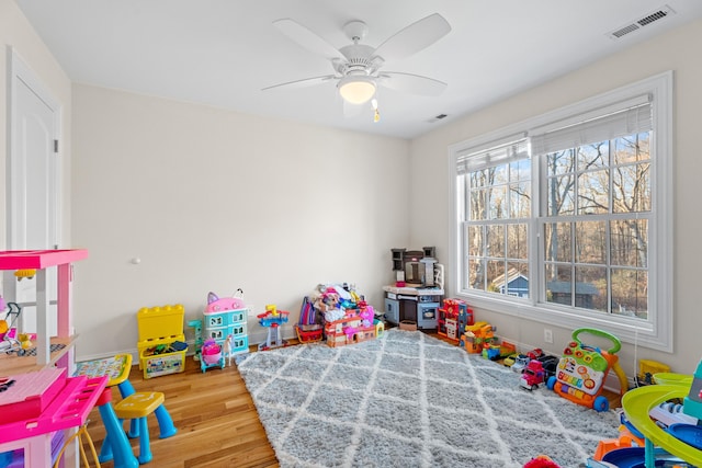 recreation room with ceiling fan and light hardwood / wood-style floors