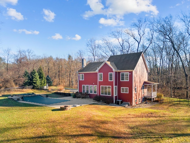 rear view of property with a yard and a swimming pool