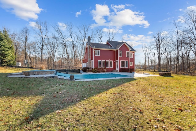 rear view of house with a patio area, a yard, and an outdoor fire pit