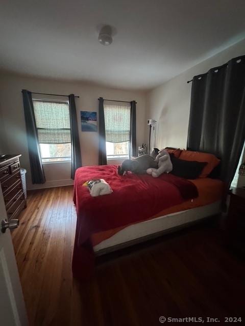 bedroom with hardwood / wood-style flooring and multiple windows